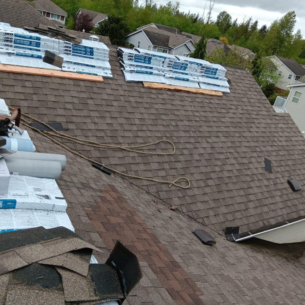 A roof with a lot of shingles being installed on it.