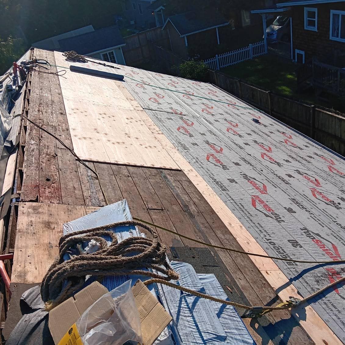 The roof of a house is being repaired with a rope.