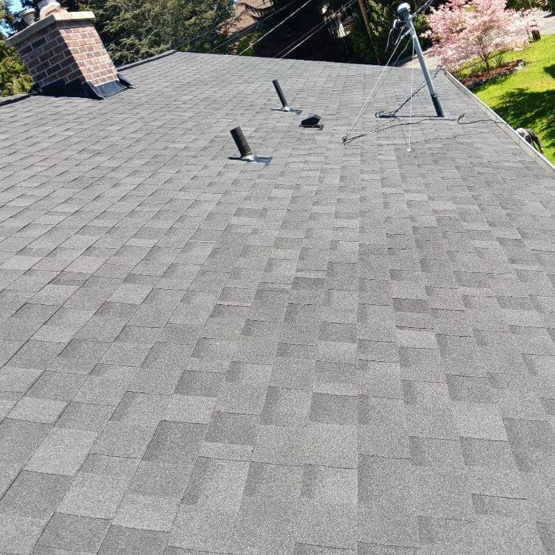 A roof with a chimney and a satellite dish on it.