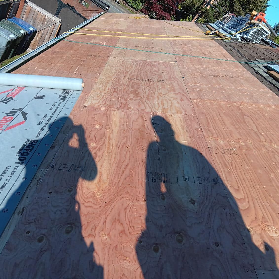 A shadow of a person is cast on a wooden roof.