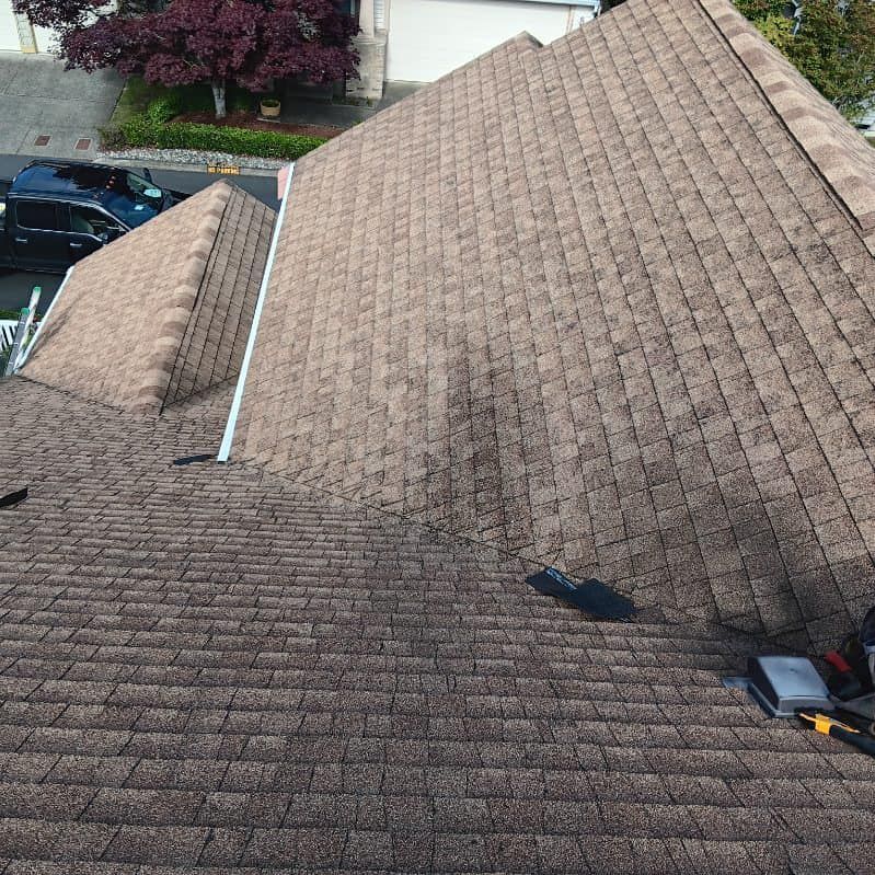 An aerial view of a roof with a car parked in the background.