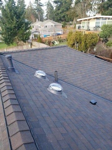 There are two skylights on the roof of a house.