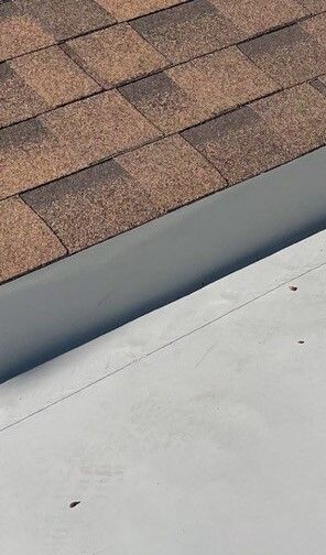 A close up of a roof with shingles and a gutter.