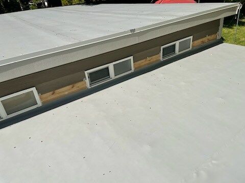 The roof of a house with a white roof and windows.