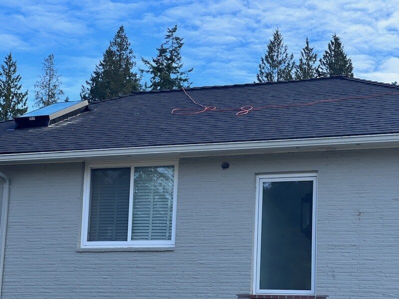 A house with a solar panel on the roof and a window.
