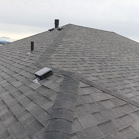 A close up of a roof with shingles and a chimney.