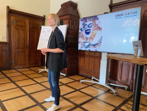 Foto von einem Event in der Marienburg Monheim, SF hält einen Vortrag, im Hintergrund Bildschirm und Flipchart