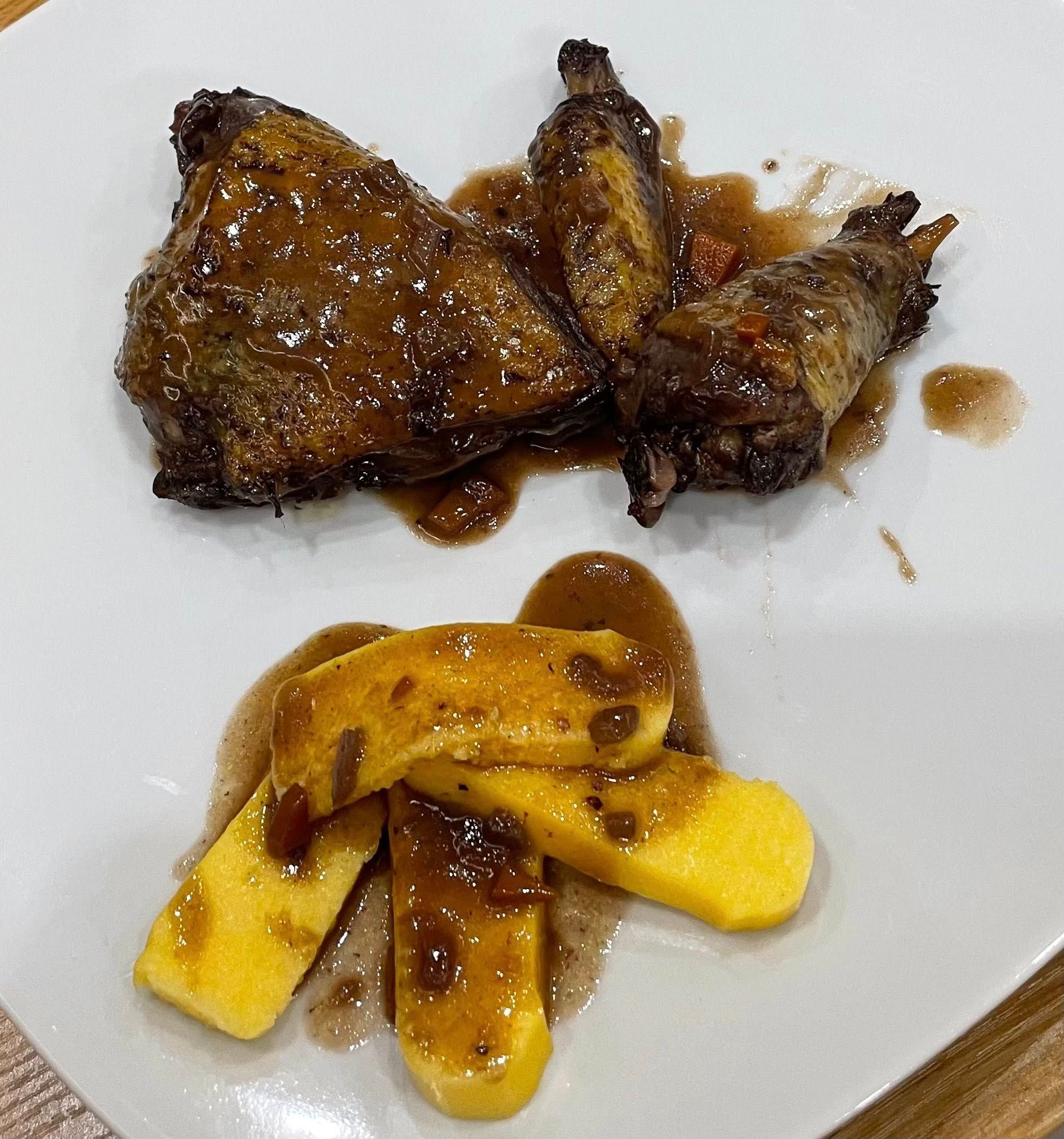Piatto di carne arrosto e bastoncini gialli fritti, conditi con salsa bruna.
