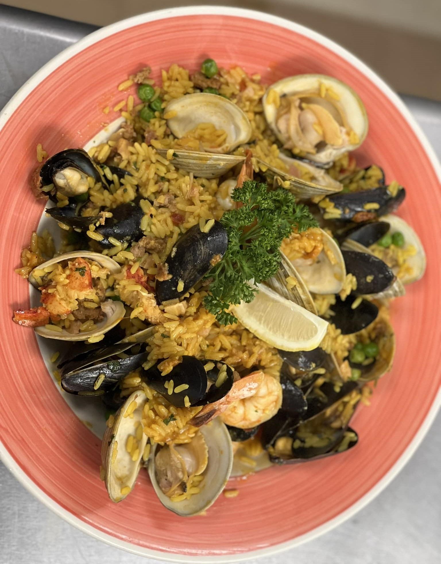 A close up of a plate of seafood paella on a table.