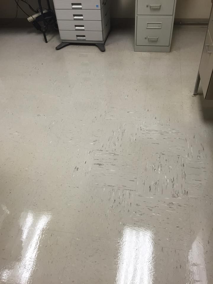 Off-white linoleum floor in an office setting, with a shiny surface and visible tile patterns.