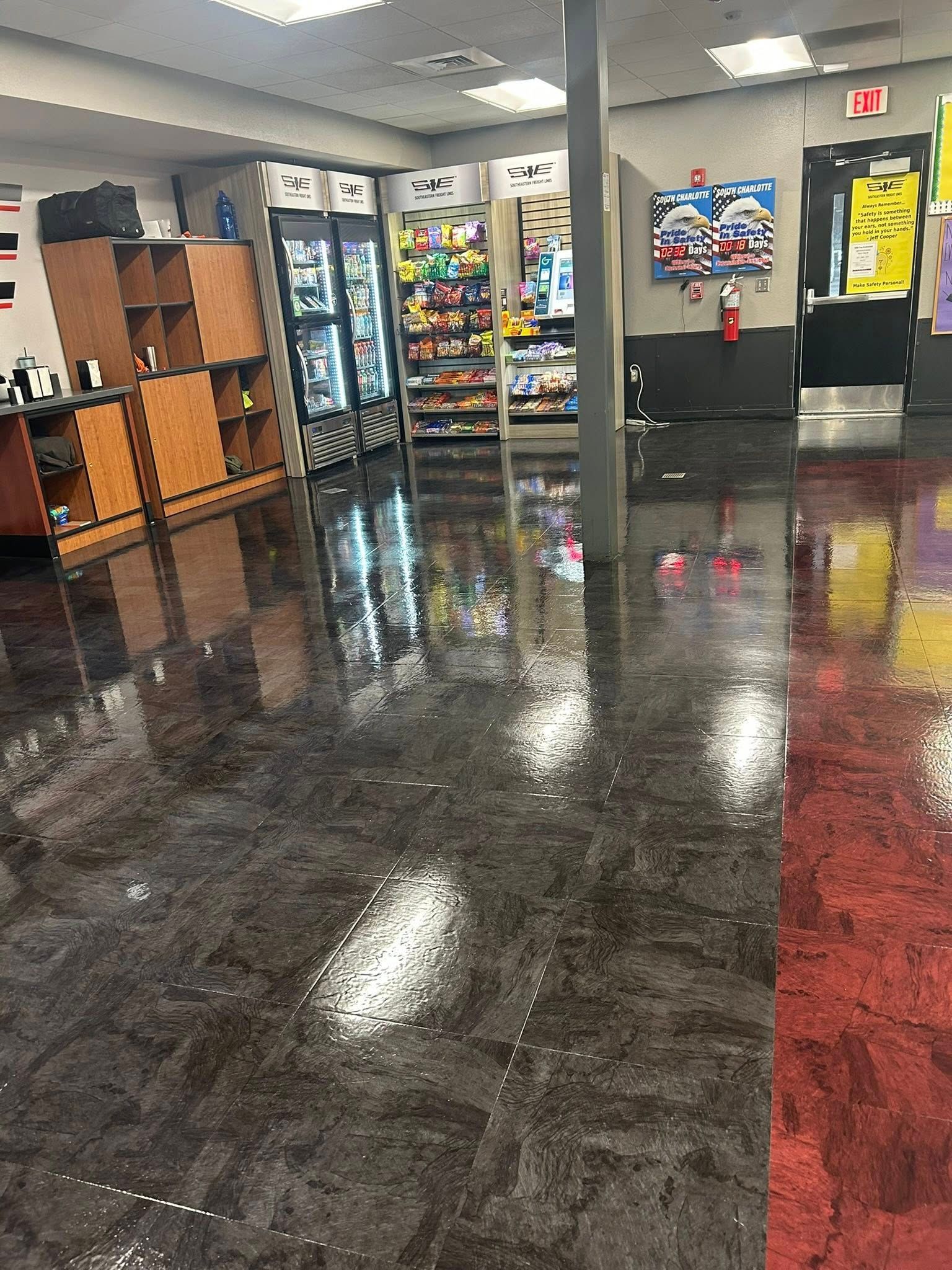 Inside a store with shiny, speckled floors. Refrigerators, shelves, and a support column are visible.
