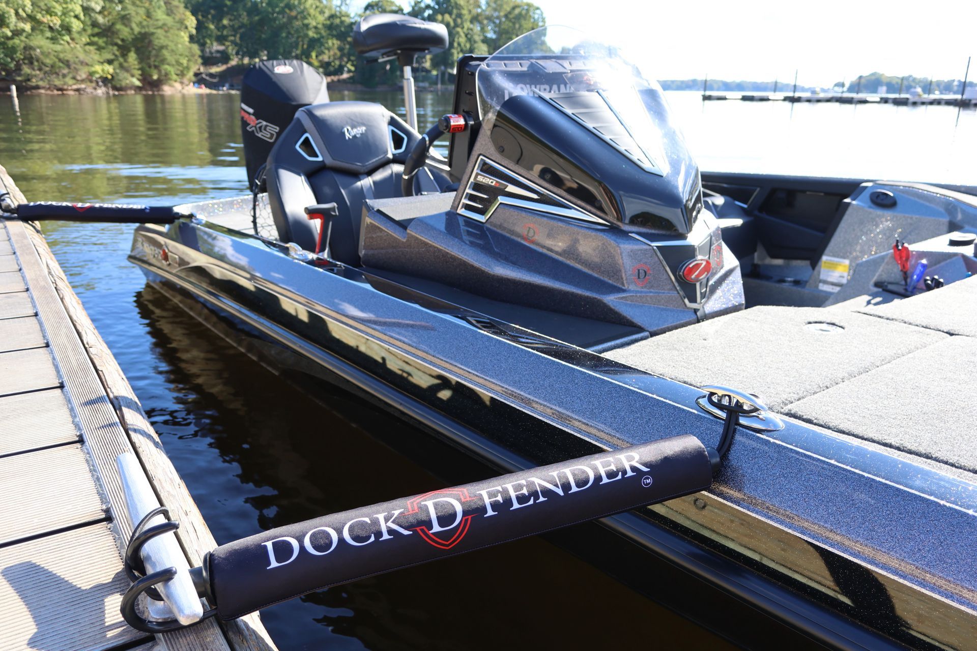 Black Dock D-Fender pair connecting a bass boat to the dock cleats, sunshine on lake, secured and protected boat