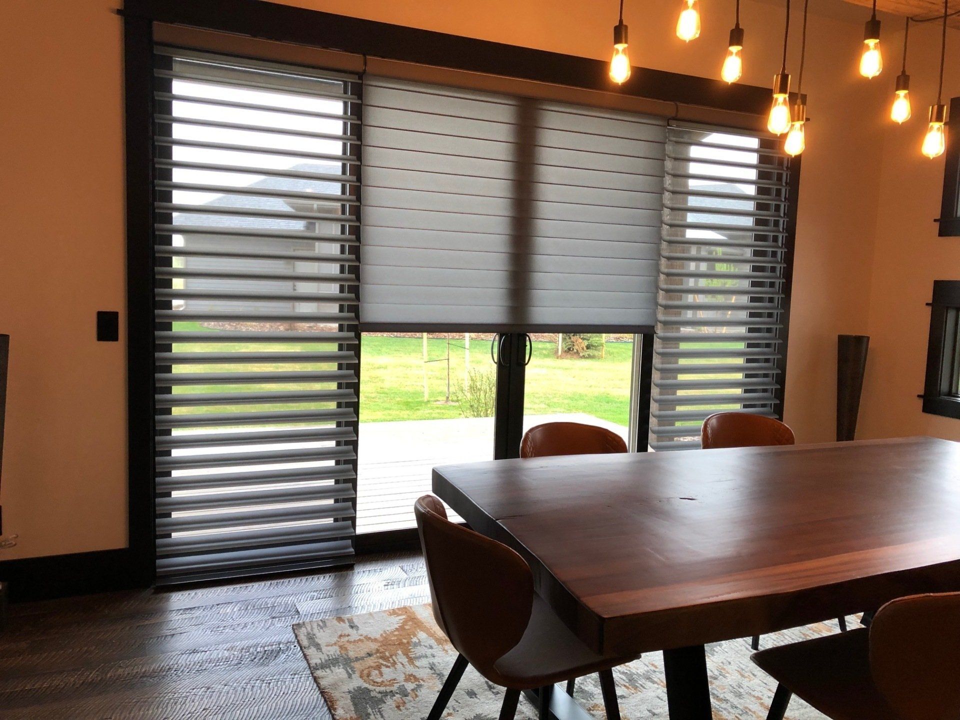 A dining room with a table and chairs and sliding glass doors.