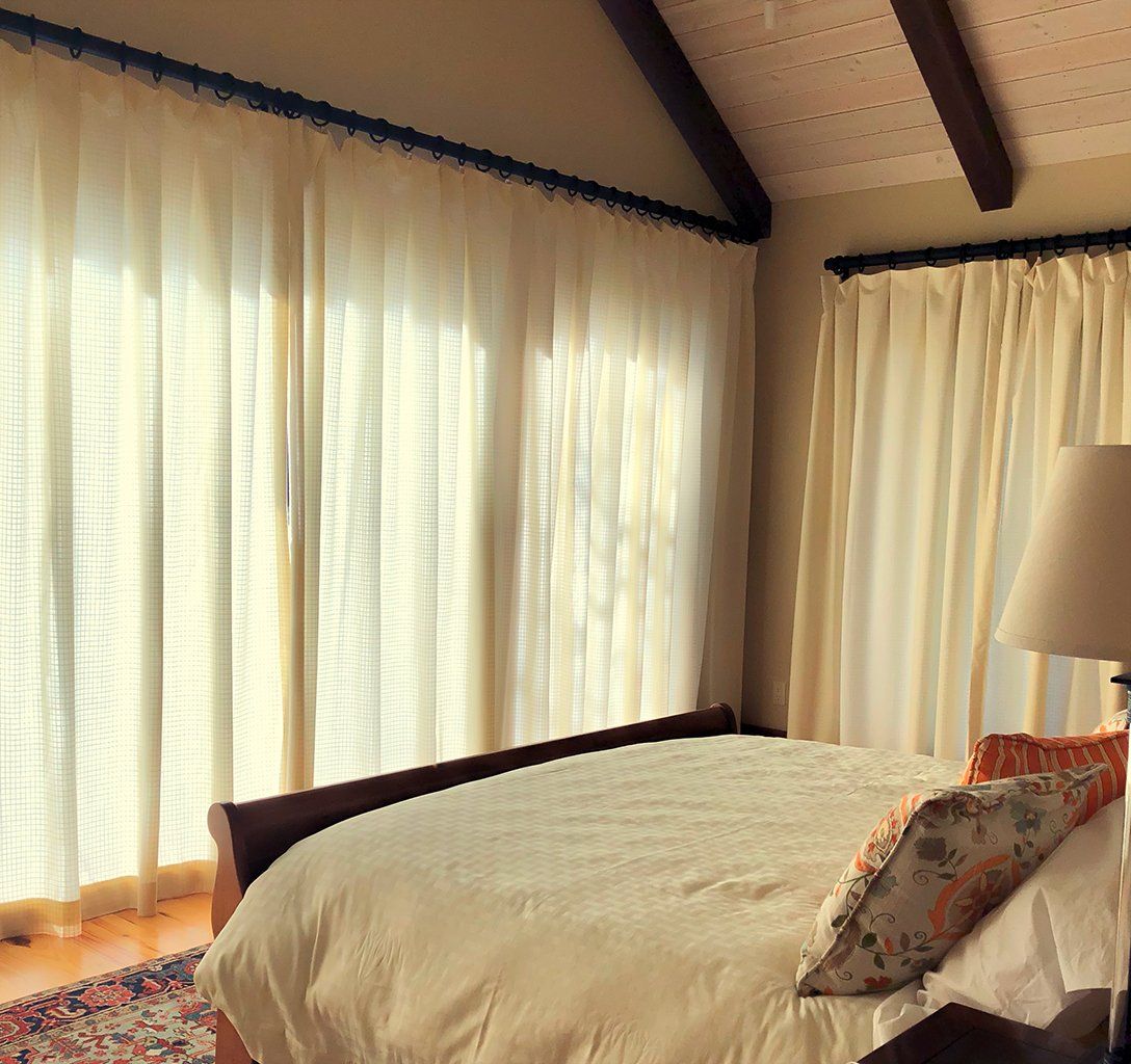 A bedroom with a large bed and lots of windows