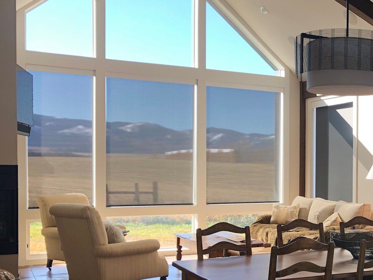 A living room with a table and chairs and a large window