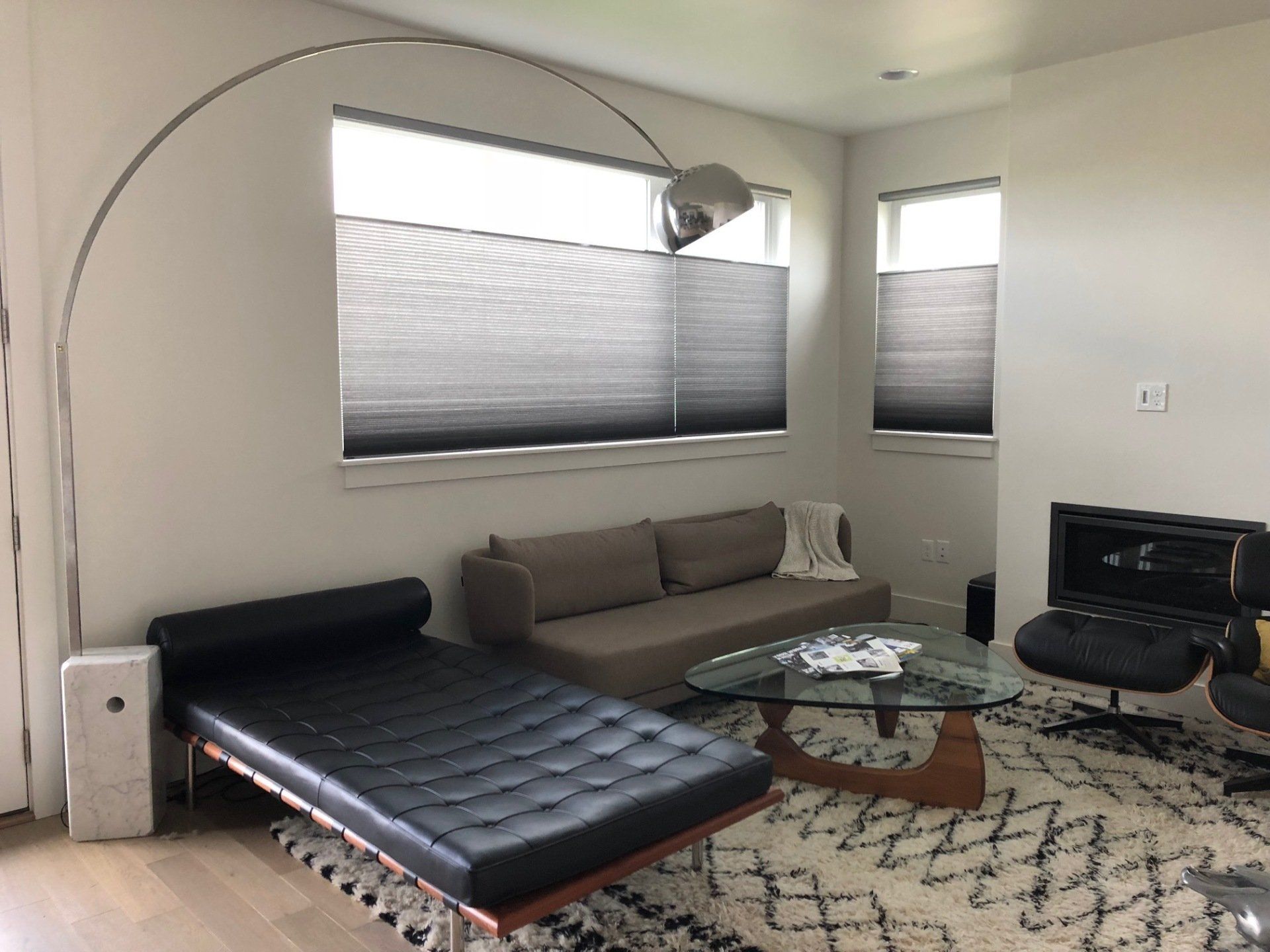 A living room with a couch , chair , coffee table and lamp.