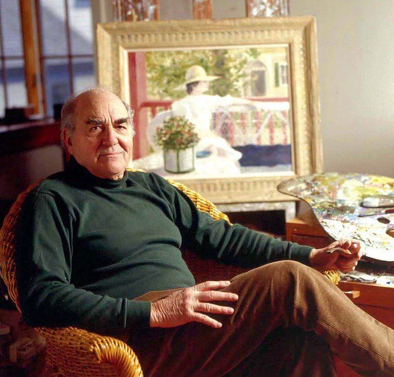 A man is sitting in a chair in front of a painting