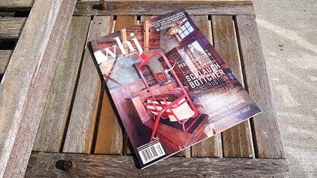 A magazine is sitting on a wooden table.