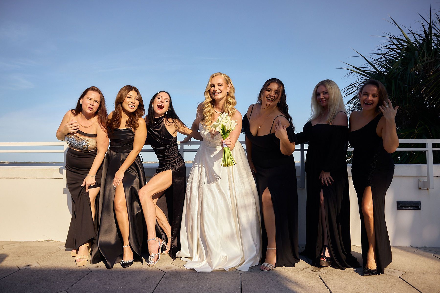 A bride and her bridesmaids are posing for a picture