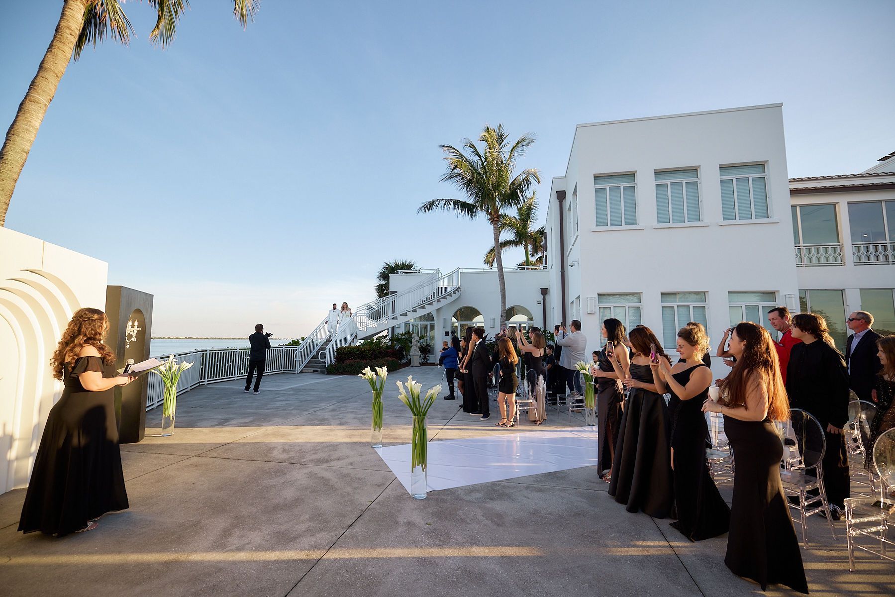 A group of women in black dresses are standing in front of a white building.