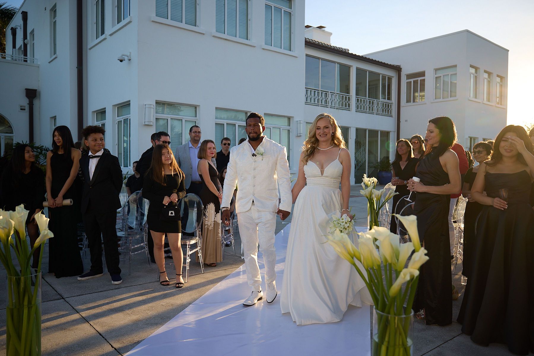 A bride and groom are walking down the aisle at their wedding