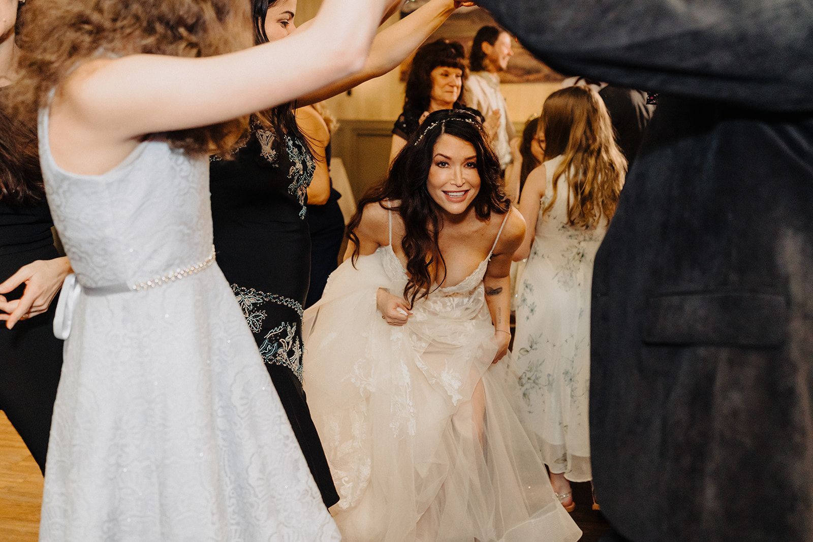 A group of people are dancing at a wedding reception.