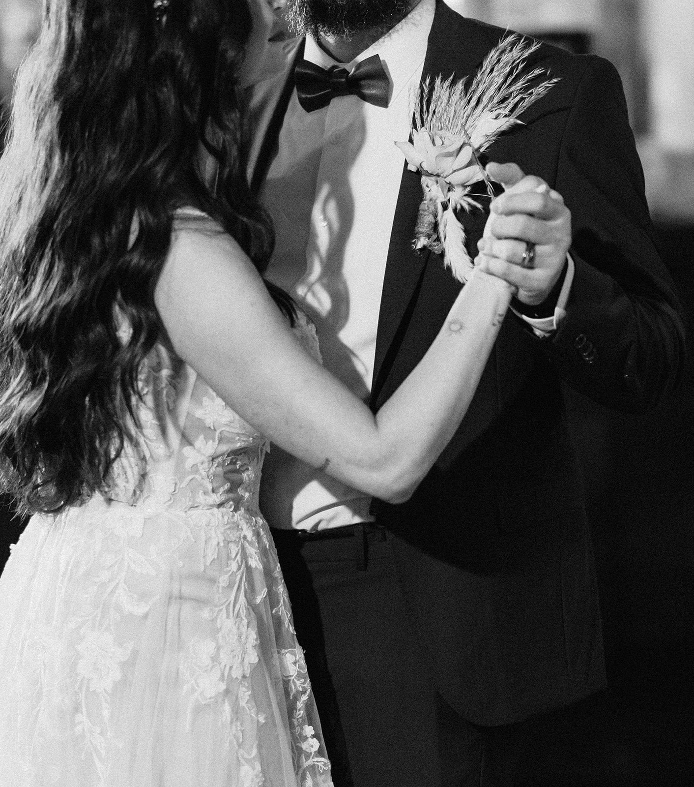 A black and white photo of a bride and groom dancing