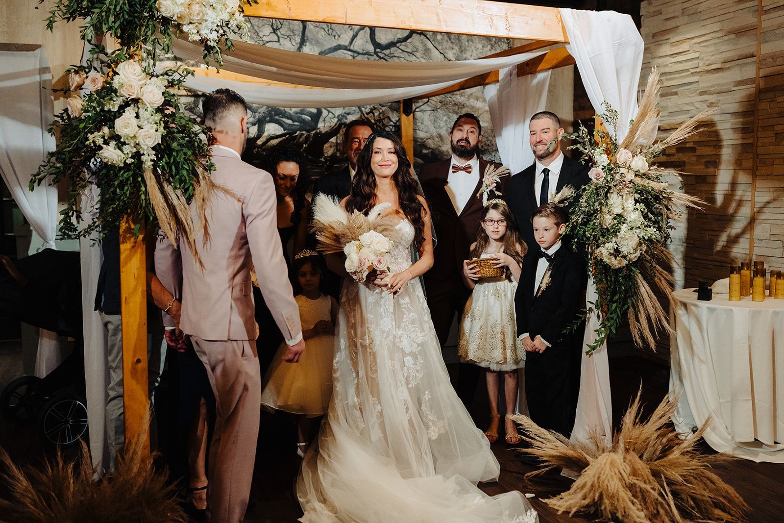 A bride and groom are walking down the aisle at their wedding under a canopy.