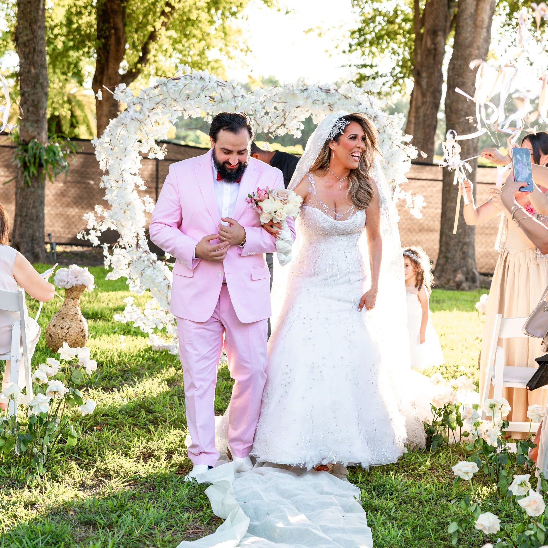 A bride and groom are walking down the aisle at their wedding