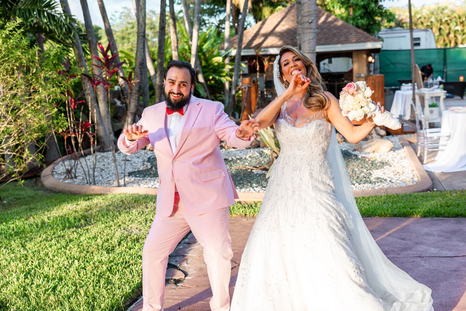 A bride and groom are posing for a picture at their wedding.