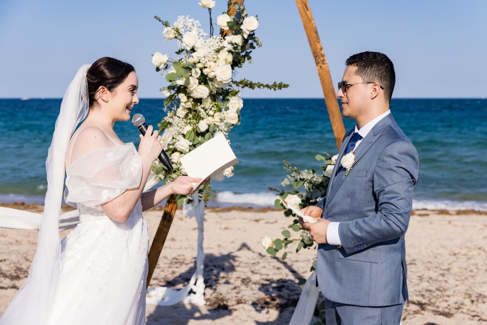 A bride and groom are having their wedding ceremony on the beach.