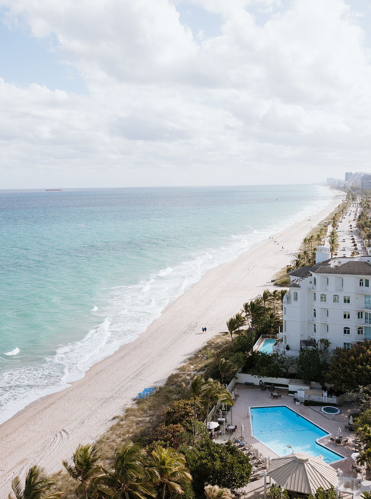 An aerial view of a beach with a swimming pool