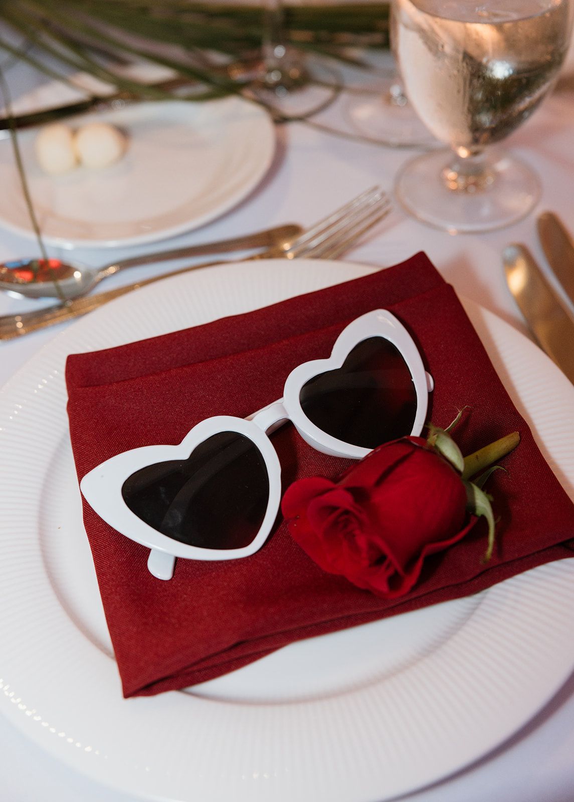 A pair of heart shaped sunglasses on a red napkin