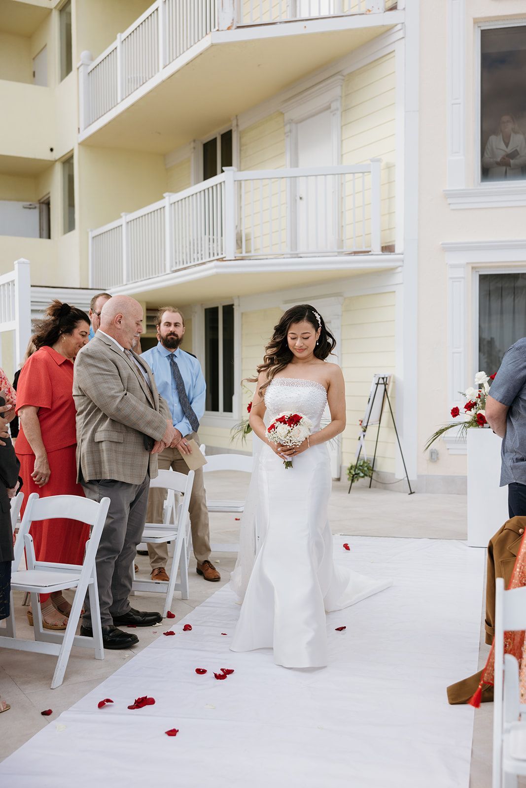 A bride is walking down the aisle at a wedding ceremony.