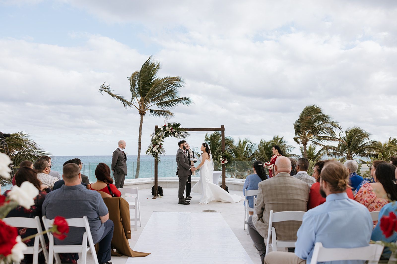 A bride and groom are getting married in front of a crowd of people.
