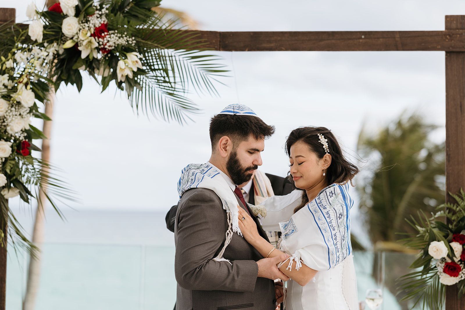 A bride and groom are holding hands during their wedding ceremony.