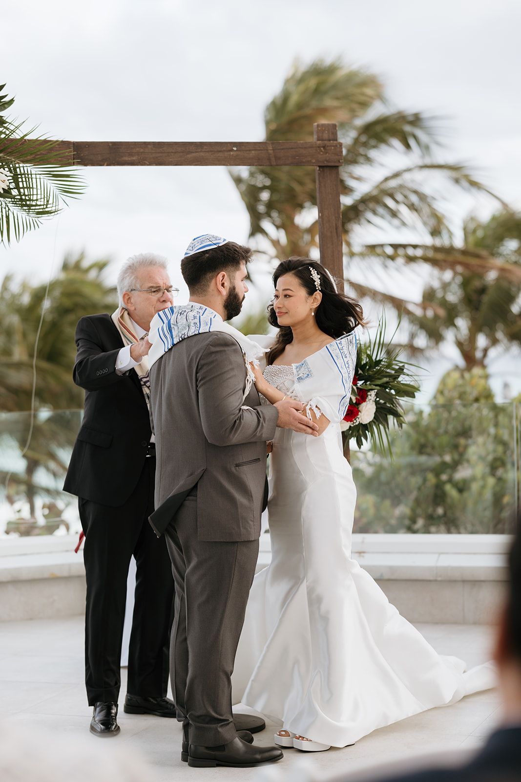 A bride and groom are holding hands during their wedding ceremony.