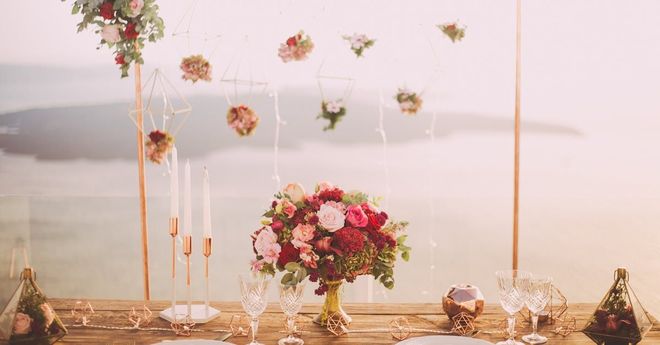 A table with a vase of flowers on it and a view of the ocean.