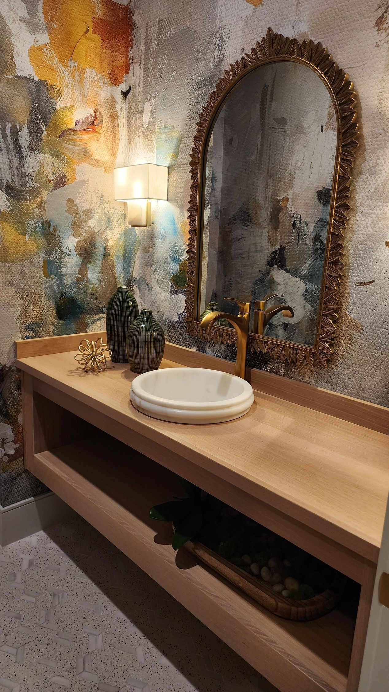A bathroom with a sink , mirror , and shelf.