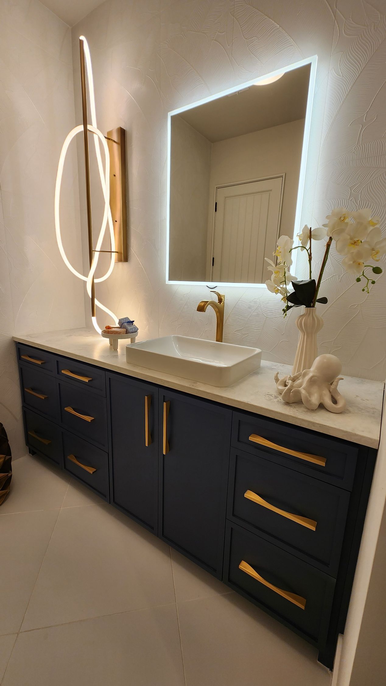 A bathroom with a sink , mirror and cabinets.