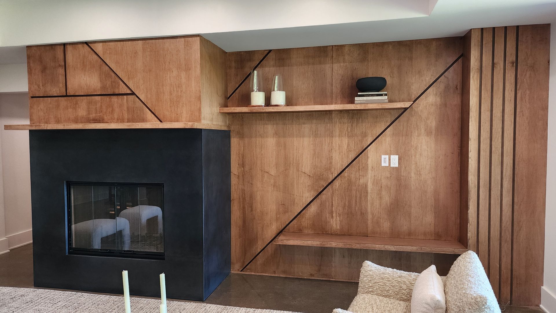 A living room with a fireplace and a television on the wall.