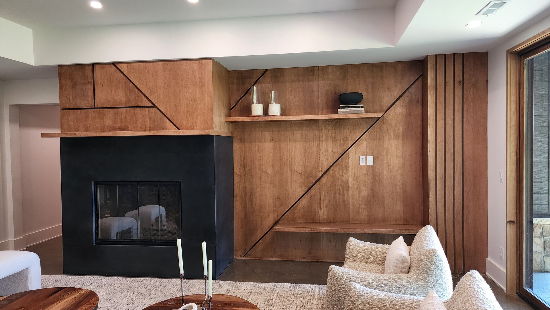 A living room with a fireplace and a wooden wall