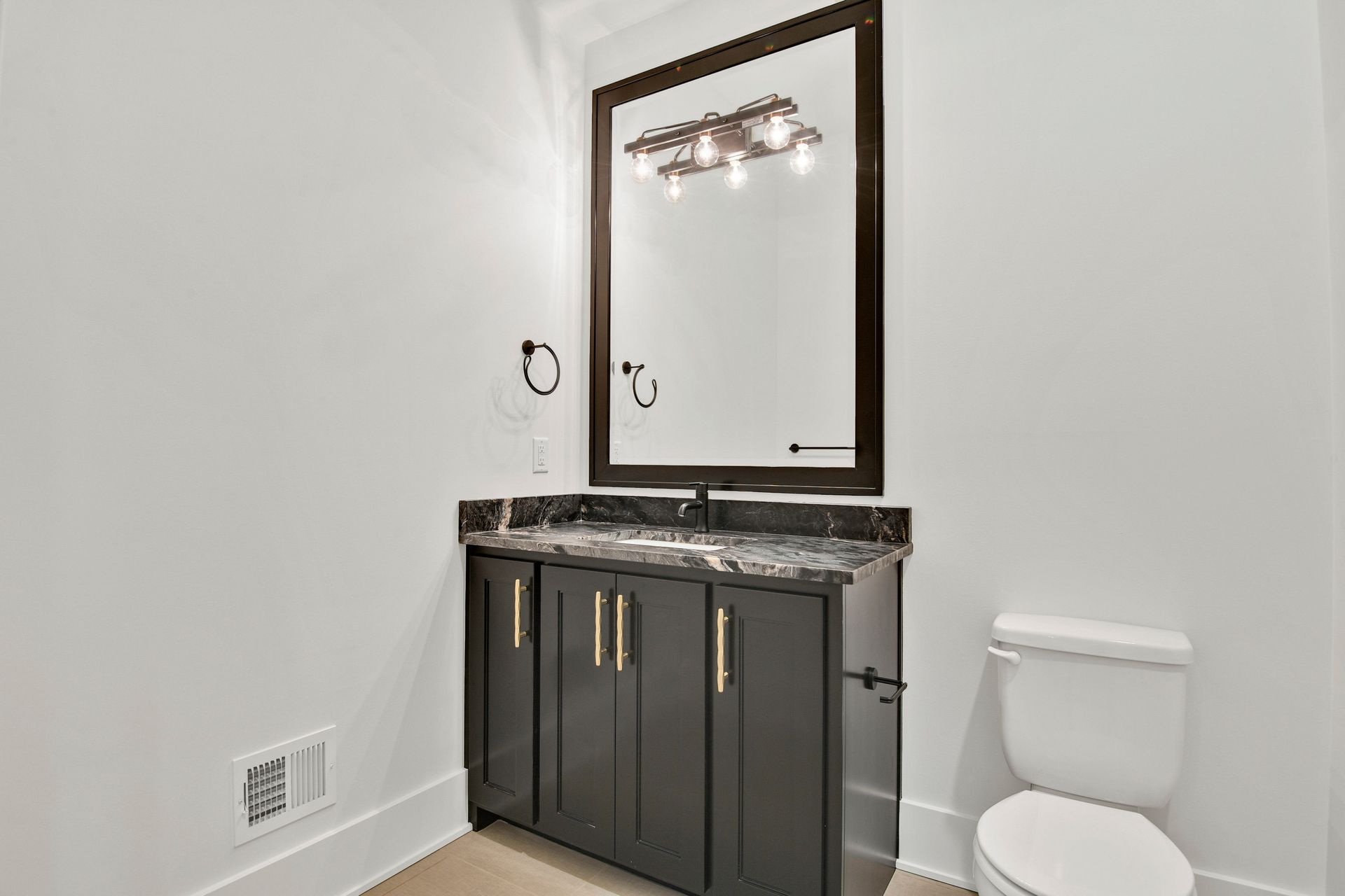 A bathroom with a sink , toilet and mirror.