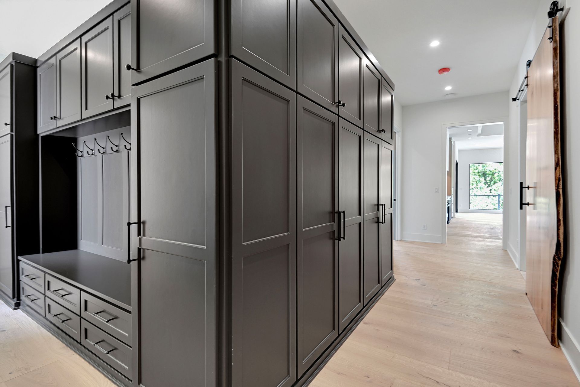 A hallway with a lot of cabinets and a sliding barn door.