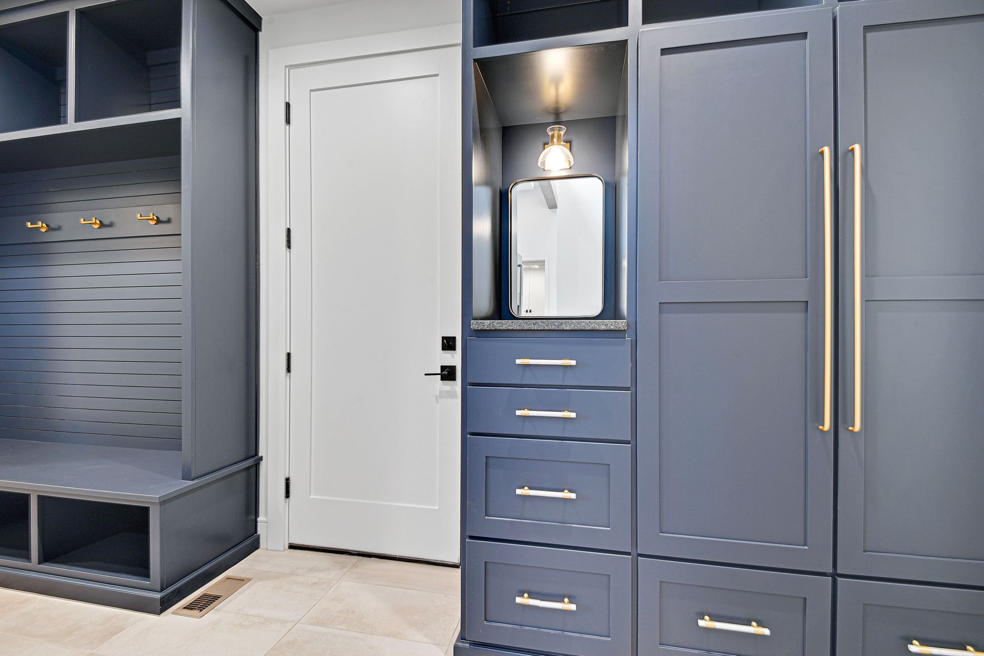 A room with a lot of cabinets and drawers and a door.