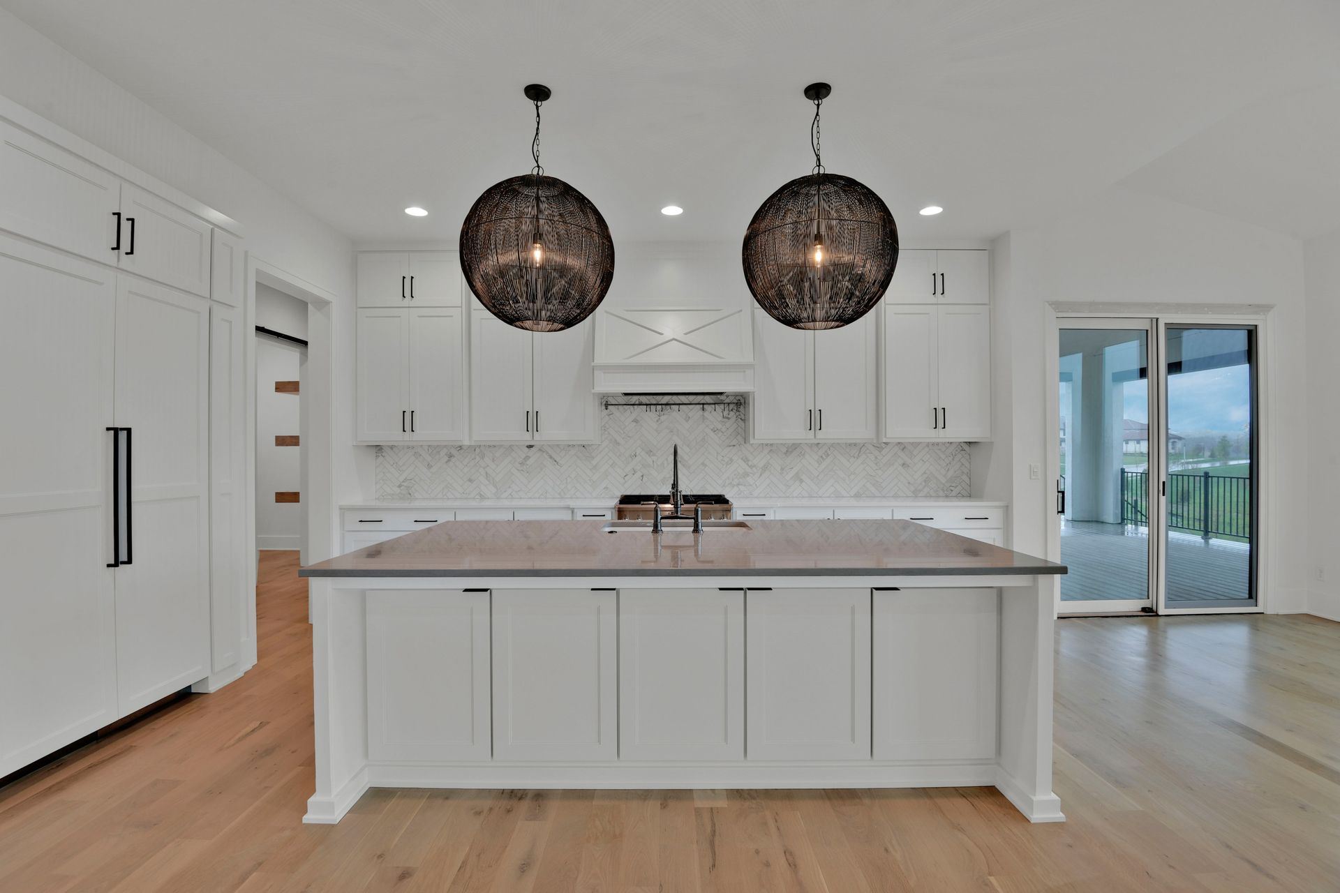 A kitchen with white cabinets and a large island
