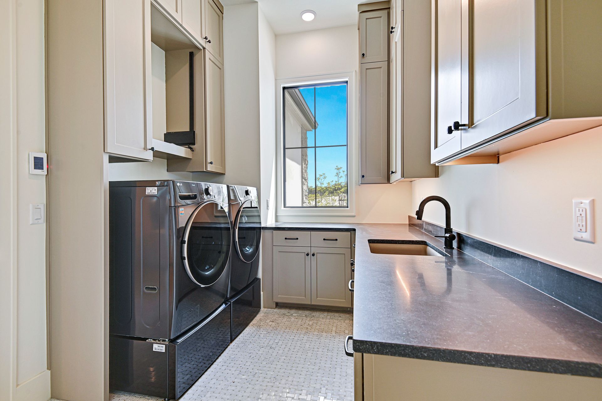 A laundry room with a washer and dryer and a sink