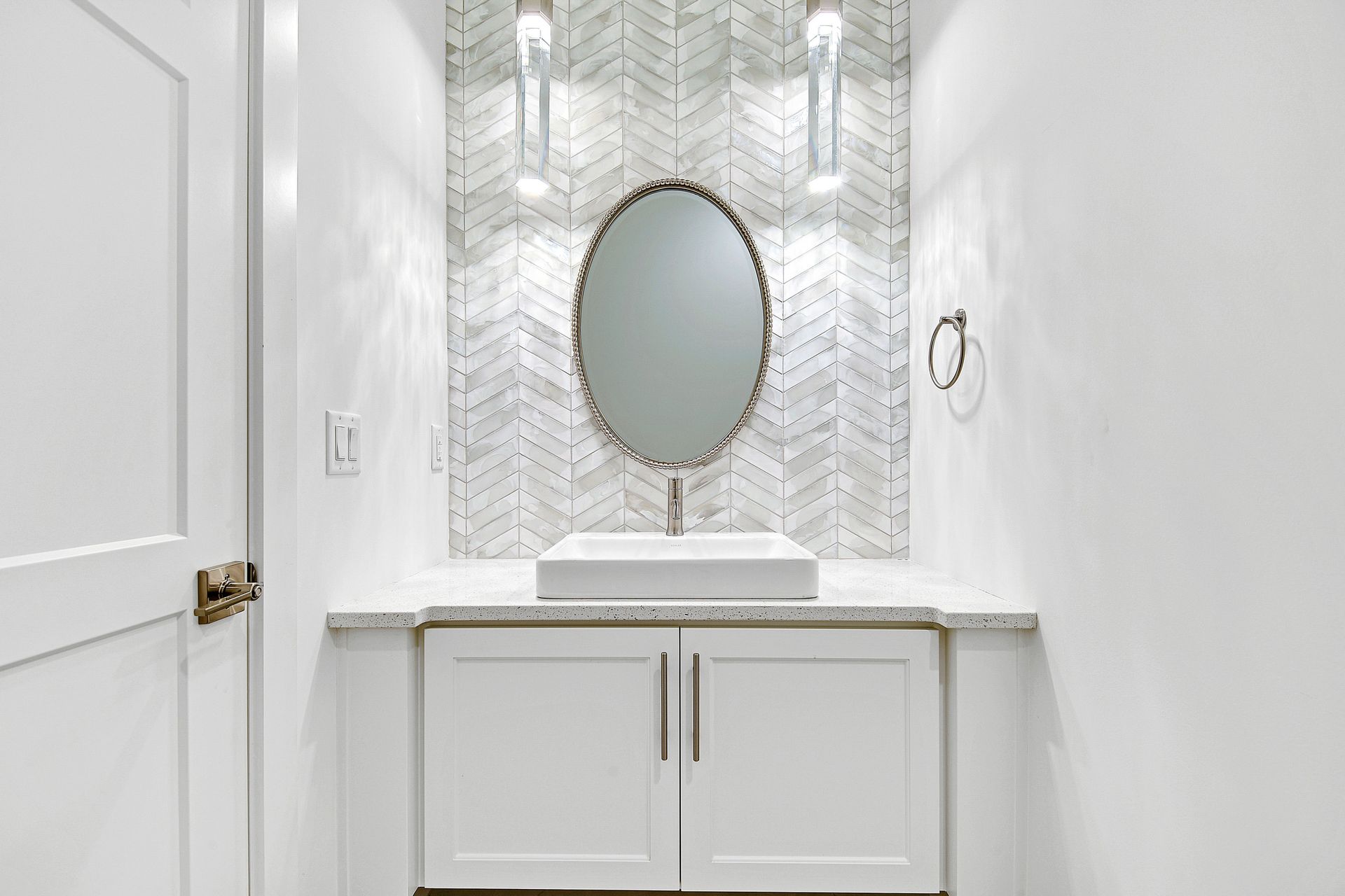 A bathroom with a sink , mirror and cabinets.