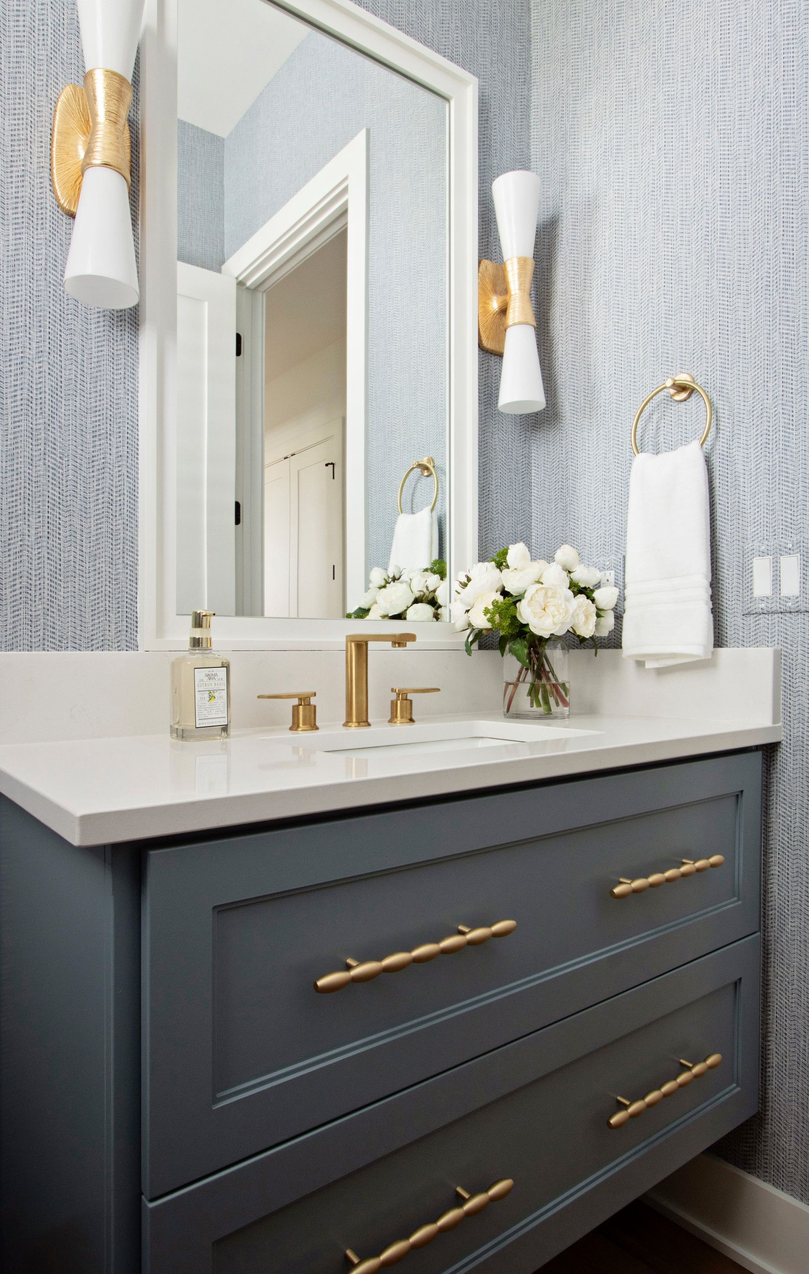 A bathroom with a sink , mirror , and drawers.