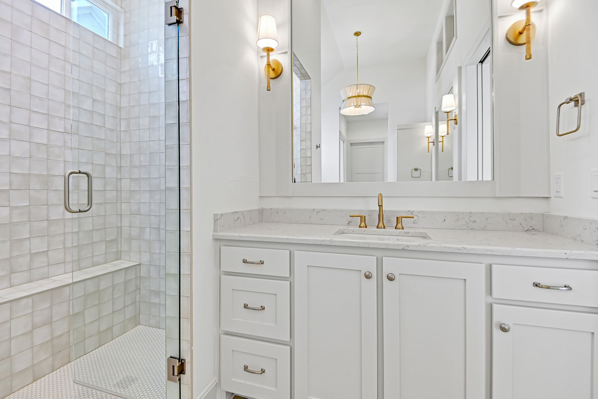 A bathroom with a sink , mirror , and walk in shower.